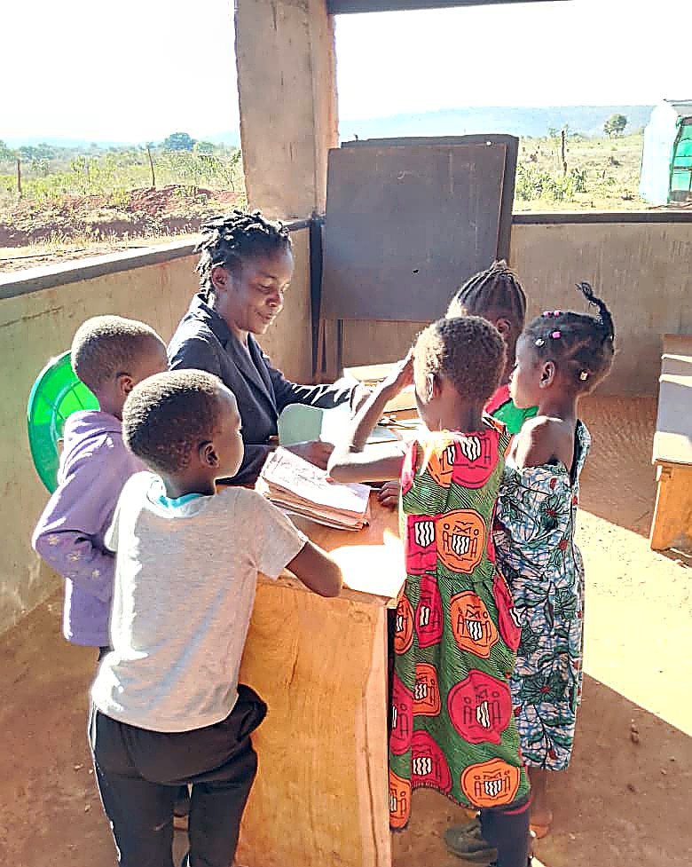 A Blessed Land Academy teacher helping young students with their lesson